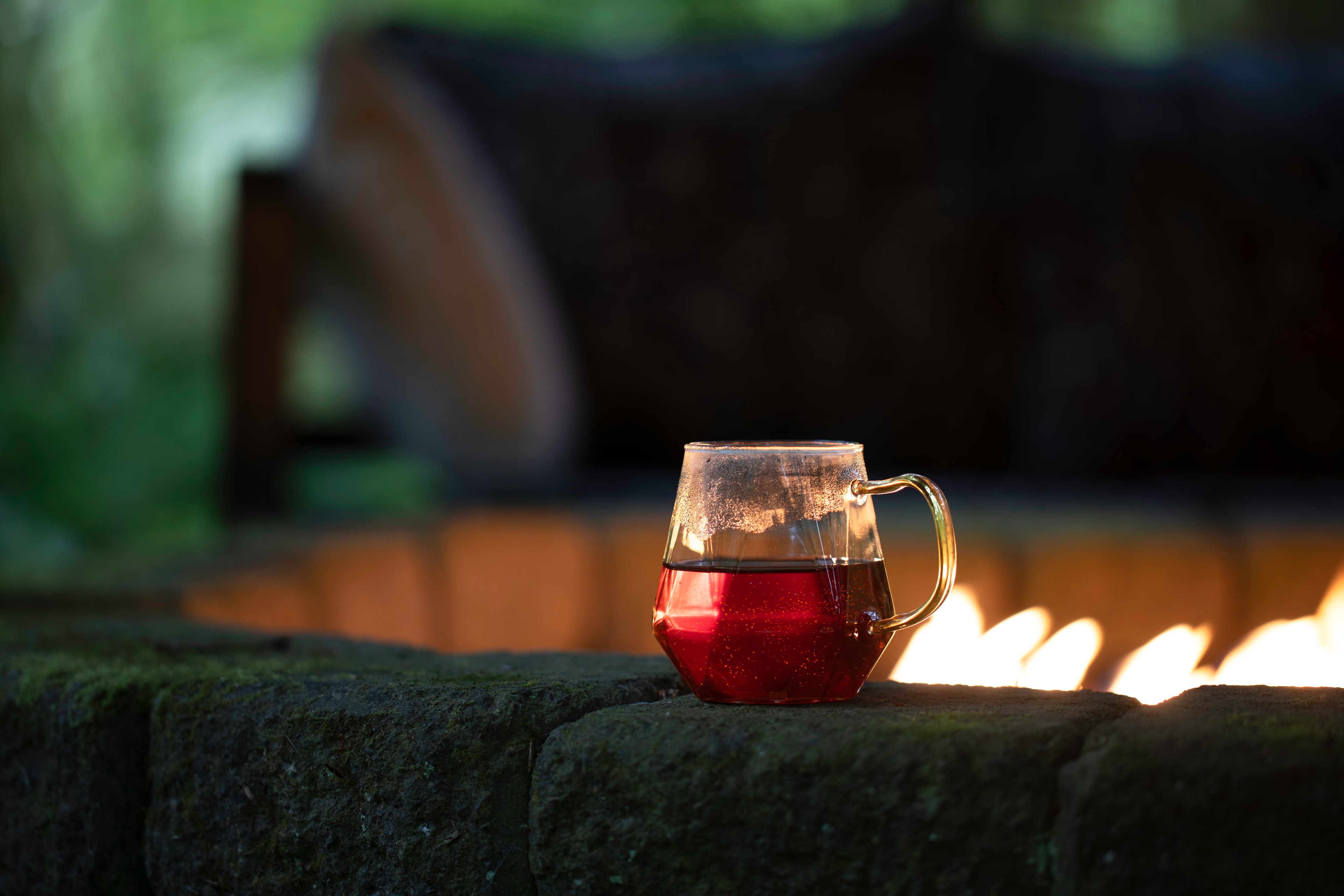 Purple herbal tea glowing among garden stones